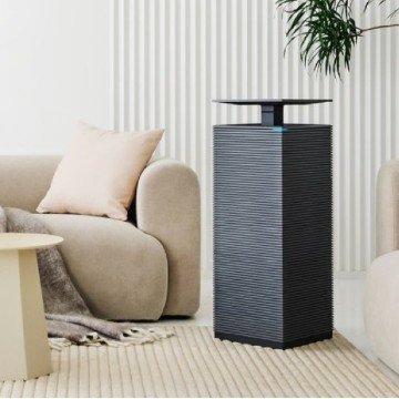 거실 소파 옆에 배치된 코웨이 노블 에어 AP-2021A 공기청정기의 슬림한 디자인과 인테리어 조화